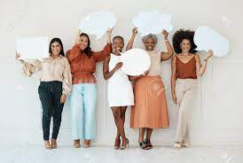 Group Of Five Diverse Young Businesswomen Standing Against A Wall In An  Office And Holding Speech Bubbles. Happy Colleagues Holding Blank Boards  While Standing In A Row Together At Work Stock Photo,