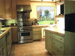 A beige mosaic tile backsplash brings depth to this large kitchen and is an elegant pairing with the room's pale green cabinetry. Terracotta And Sage Green Kitchen Novocom Top