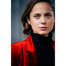 Zwischen Blau und Blick: Schauspielerin Lena Vogt vor einer klaren  Farbkulisse. Ihre Augen greifen das Blau der Wand auf