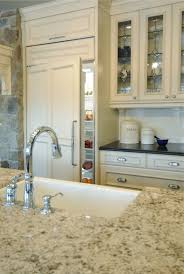 The cream backsplash and under mount lighting opens up the space and creates a nice contrast between the dark grey cabinets and black countertops. Cream Cabinets With Black Granite Countertops Design Ideas