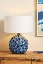 The round hardback drum shade is a white linen fabric. Lucille Blue Ceramic Table Lamp