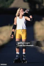 Teenage Girl Holding Skateboard And Blowing Bubble High-Res Stock Photo