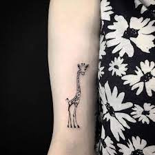 Giraffe Tattoo On The Right Bicep Giraffe Tattoos Giraffe Tattoo Ideas Tattoos