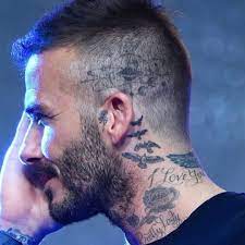The back of the photo of david beckham visible tattoo with a cross with wings and the name of the second son of «romeo». La Imagen Puede Contener Una O Varias Personas Barba Y Primer Plano Tatuagem No Pescoco Tatuagem No Pescoco Masculino Tatuagem De Louros