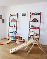 Playroom Ladder Shelves With Grimm S Toys And Triclimb Pikler Triangle And Indoor Slide Felted Wobbel Board Montessori Furniture Playroom Toys