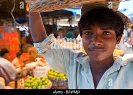 Portrait of a porter in Crawford Market (Mahatma Jyotiba Phule Market), a  wholesale fruit market in Mumbai, India, balancing his basket over his head  Stock Photo
