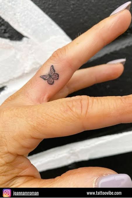A dainty butterfly finger tattoo