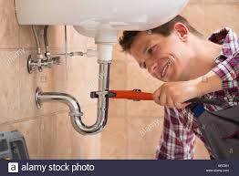 plumber fixing sink pipe with