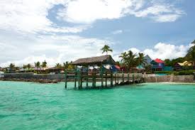A stylish crowd sips potent cocktails on the pool deck with the deep blue sea as a backdrop. Compass Point Beach Resort Hotel Review Nassau Bahamas Travel