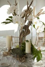 Tall Centerpiece Of Driftwood And Orchids With Succulents And Tropical Leaves Driftwood Wedding Centerpieces Flower Centerpieces Driftwood Wedding