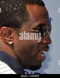 Recording artist Sean "Diddy" Combs hugs Los Angeles Clippers' Chris Paul  as Combs' son looks