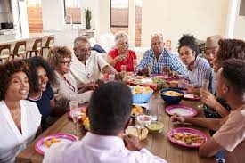 Young happy family talking while having lunch at dining table. Can Workplace Diversity Change Discussions Around The Dinner Table