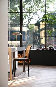 Maybe you would like to learn more about one of these? A Grid Of Square Black Window Frames Cover The Back Wall Of This Renovated House