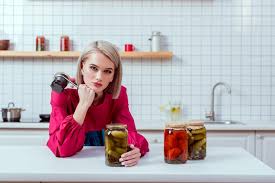 With the unique designs of the jars and the change in the way people store their medicine. Beautiful Fashionable Housewife Looking At Camera And Holding Seamer With Jars Of Pickled Vegetables On Kitchen Counter Free Stock Photo And Image