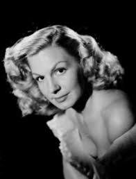 Zully Moreno, en tres cuartos, se apoya en una columna, viste blusa de  escote amplio, retrato