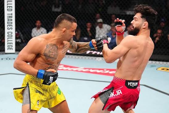 Márcio Barbosa landing a punch on Dennis Buzukja in the Octagon