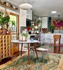 A boho dining nook with printed pillows, a black round table and a metal pendant lamp. Top Ideas To Get Boho Style Kitchen Hippie Boho Gypsy