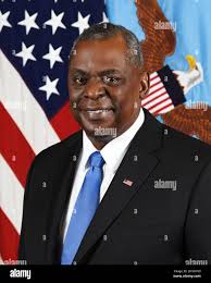 Secretary of Defense Lloyd J. Austin III greets U.S. Navy Lt. Andrew  Couillard and U.S. Marine Master Sgt. Matthew Jackson after a briefing and  tour of unmanned surface vehicle technology at Naval