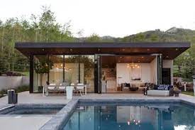 White stucco veneer with light wood siding. This Can Do Pool House Cleverly Goes From Private To Party Mode Dwell