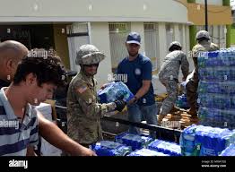 U.S. Army reservists with the 1st Mission Support Command and emergency  disaster responders transfer water cases to a distribution truck in Juana  Diaz, Puerto Rico, Oct. 1, 2017. FEMA, the Department of