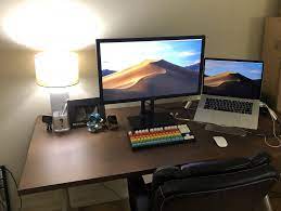 A Large Wooden Desk With A Laptop A Monitor A Rainbow Keyboard And Some Desk Toys Remote Workers Remote Work Remote
