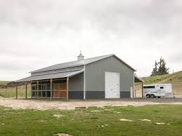Pole barn (walls light stone with berry trim, roof galvalume) framed garage on a slab, overhead doors (tan walls, roof, and green trim) framed gambrel on a slab, overhead door, pole side shed (light grey walls, white trim and a charcoal gray roof) Agricultural Northwest Steel