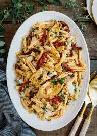 Artichoke Pasta Salad Recipe With Sun Dried Tomato Vinaigrette On A White Serving Platter Tomato Pasta Salad Pasta Salad Artichoke Recipes