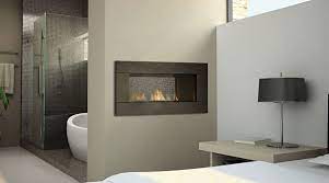 The warm fire, the crackling of burning wood, and the soft glow are perfect to create a relaxing mood. Fireplaces Between Rooms Kitchen Lounge Bathroom Bedroom Fireplace Between Rooms Contemporary Gas Fireplace Home