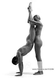 Nude man and woman, man doing handstand, woman holding man s ankles, side  view, b&w