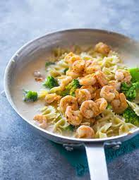 Greek yogurt and cream cheese are used in place of butter and heavy cream in this makeover alfredo sauce with shrimp, broccoli, and a touch of smoky bacon. Skinny Garlic Shrimp Broccoli Alfredo Gimme Delicious