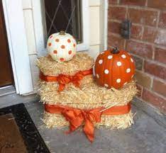 A basket filled door ornament surrounded by corn stalks, mums and a leaf garland complete this classic fall decor. Hay Bale Decorating Ideas Hackmann Lawn Landscape