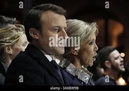 Incoming French President Emmanuel Macron and his wife Brigitte Macron sing  the national anthem after he delivered a speech in front of the Pyramid at  the Louvre Museum in Paris, Sunday, May