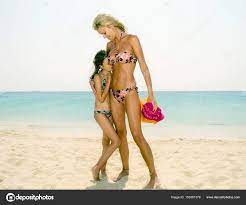 Woman and girl standing at beach Stock Photo by ©ImageSource 159367378