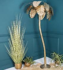 This piece features a gold leaf finish with a light gray wash and a matte black foot. 10 Statement Palm Tree Lights