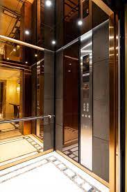 Levele 105 Elevator Interior With Customized Panel Layout Panels In Bonded Bronze With Dark Patina And Charles Elevator Interior Elevator Design Lift Interior