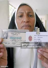 Wafa Abbas who works for Iraq's Southern oil company holds her old ID...  News Photo
