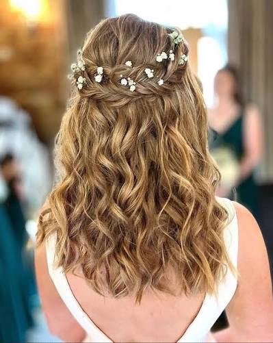 This bridal hairstyle is pure magic! ✨ Loose waves, a braided crown, and a touch of baby's breath make for a dreamy look straight out of a fairytale. Drop a 💕 if