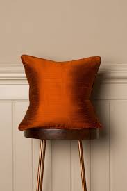 Place throw pillows on a bare sofa to spruce up the furniture's design. Medium Silk Cushion In Burnt Orange Shibumi