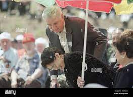U.S. Ambassador to Japan Walter Mondale, back center, assists Yoshii  Kuribayashi, widow of late Lt. Gen. Tadamichi Kuribayashi, as she returns  to her seat after giving a speech during the Iwo Jima