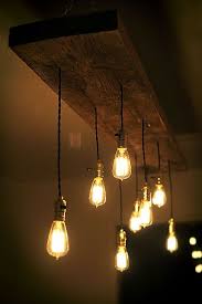 Fixture fashioned from 6 log with 6 lights hang from the beam via wrapped black twisted cloth cord. Light Illumination I Chose This Photo For Illumination Because The Light Bulbs Provide Illumination To The Hanging Light Bulbs Edison Bulb Chandelier Lights