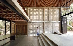 Terracotta coloured stucco exterior house wall with green succulent plant on windowsill. Wall House Anupama Kundoo Architect