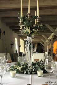 blumendekoration mit hohem kerzenleuchter fur runde tische dekoration blumendekoration kirchenschmuck