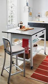 The kitchen island is anchored by a shelf styled like a baker's rack to stow pots, cookbooks or baking supplies. Sheridan White Kitchen Island Kitchen Chicago By Crate Barrel Houzz