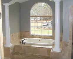 Lovely bathroom boasts a gray tiled tub fitted with a deck mount gooseneck tub filler accented with a gray mosaic tile surround placed under a window illuminated by a robert abbey beehive pendant. 10 Ideas For Bathtub Surrounds
