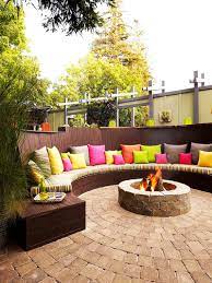 Stone pit with a rainbow of chairs. Best Outdoor Fire Pit Ideas To Have The Ultimate Backyard Getaway