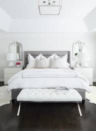 A White Leather Tufted Bench Is Placed In Front Of A Gray Channel Tufted Bed Dressed In Whit Bedroom Setup Luxury Bedding Master Bedroom Bedding Master Bedroom