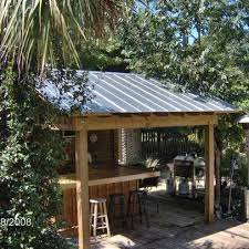 A trellis cover creates a fun sunlight pattern on the surfaces of this modern outdoor kitchen. Green Roofs And Great Savings Backyard Bar Outdoor Tiki Bar Bar Shed