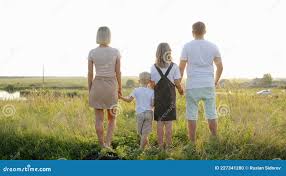 Little Son Smiles at the Camera. the Family Joined Hands and Stands at  Sunset. Dad, Mom, Children are Holding Hands. the Stock Photo - Image of  concept, nature: 227341280