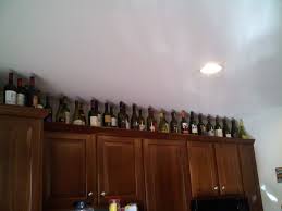 Wine Bottles On Cabinet Jpg 2 048 1 536 Pixels Above Kitchen Cabinets Wine Bottle Recycled Bottles
