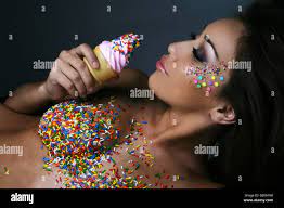 Nude woman with sprinkles eating ice cream Stock Photo - Alamy